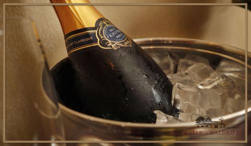 a bottle of champagne in a pot of ice at Water on Waldrift Guesthouse in Vereeniging