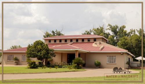 a house with a red roof at Water on Waldrift Guesthouse in Vereeniging
