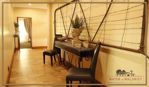 a living room with a piano and a chair at Water on Waldrift Guesthouse in Vereeniging