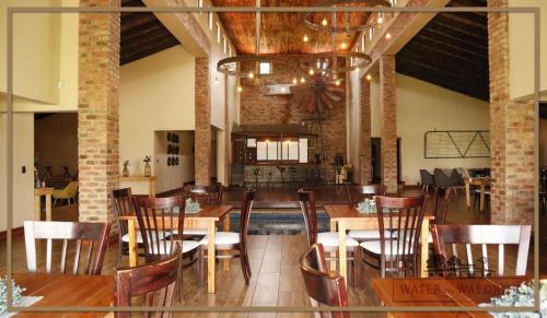 a dining room with tables and chairs in a building at Water on Waldrift Guesthouse in Vereeniging