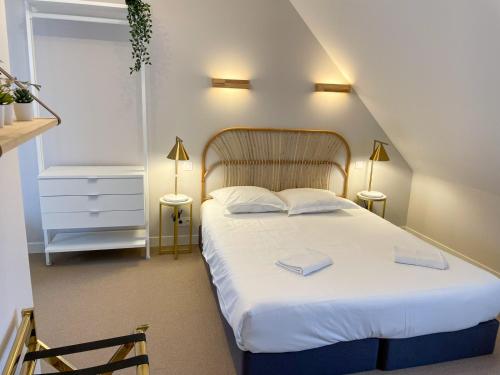 a bedroom with a bed with two towels on it at Maison des fleurs in Saint-Aignan