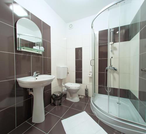 a bathroom with a sink and a toilet and a shower at Pensiunea Select in Alba Iulia