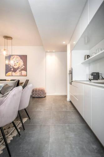 a kitchen with white cabinets and a table and chairs at Modern and Design 1 BD apt close to the beach in Tel Aviv