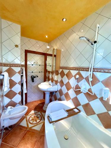 a bathroom with a tub and a toilet and a sink at Chalet am Kurpark in Boppard