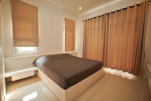 a bedroom with a bed and a window at Blue cat Pool Villa in Chanthaburi