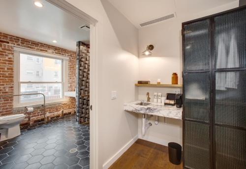 a bathroom with a shower and a toilet and a sink at Venice V Hotel in Los Angeles