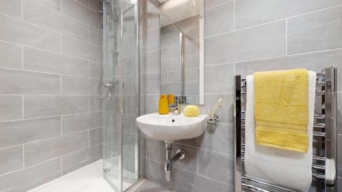 a white bathroom with a sink and a shower at Modern and Stylish Studio Apartments at Westcombe House in Greenwich in London