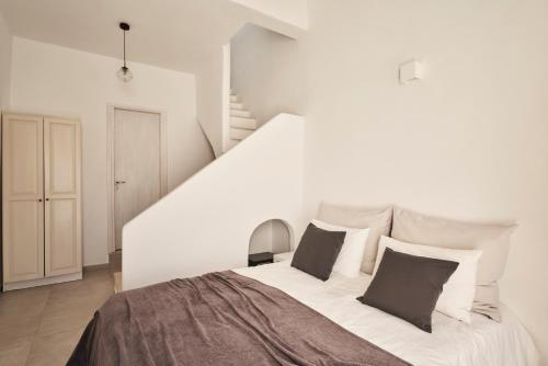 biała sypialnia z dużym łóżkiem z 2 poduszkami w obiekcie TOWN BOX w mieście Mykonos