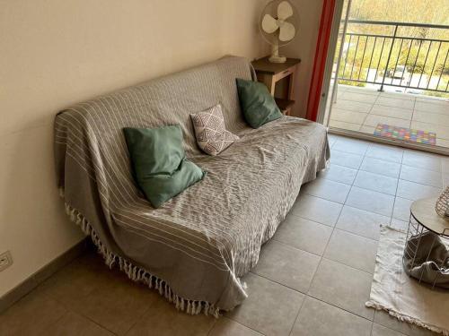 a couch with pillows on it in a room at Superbe appartement au porte de Montpellier in Juvignac