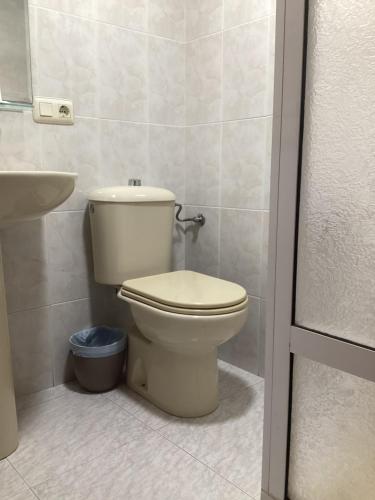 a bathroom with a toilet and a sink at Saudade Hostal Cafetería in A Coruña
