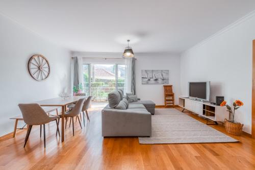 a living room with a couch and a table with chairs at Jardim do Jasmineiro in Funchal