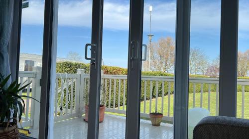 a sliding glass door with a view of a balcony at Skegness,North shore holiday park , new 8 berth caravan for rent in Skegness