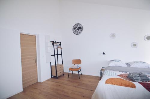 a bedroom with a bed and a clock on the wall at Studios Lsquare-Residence in Châtellerault