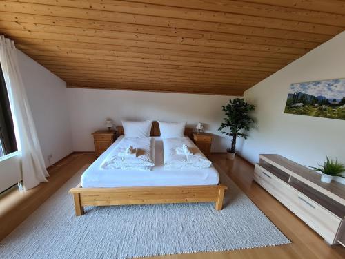 a bedroom with a bed and a wooden ceiling at Schönes Ferienhaus am Herrenberg in Prien am Chiemsee