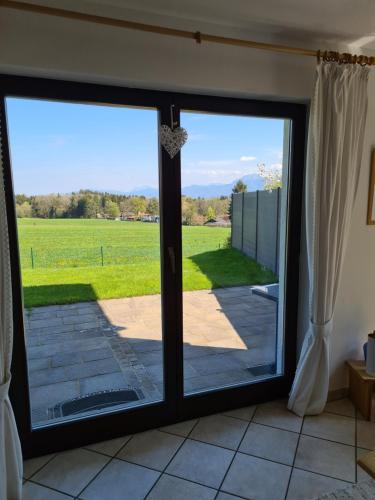 a sliding glass door with a view of a field at Schönes Ferienhaus am Herrenberg in Prien am Chiemsee