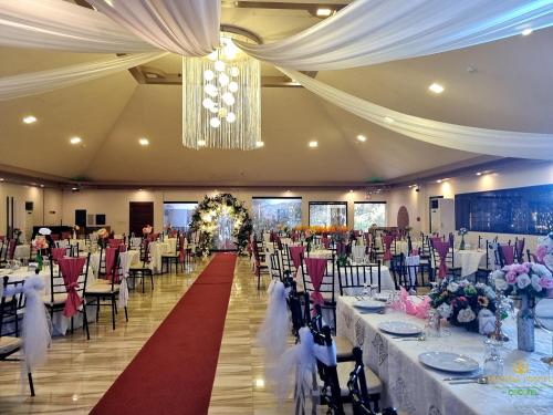 un salón de banquetes con mesas y sillas y una lámpara de araña en Buddha Resort by Cocotel, en Bugallon