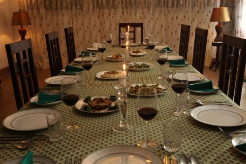 a long table with plates of food and wine glasses at Sourenee Tea Estate in Mirik