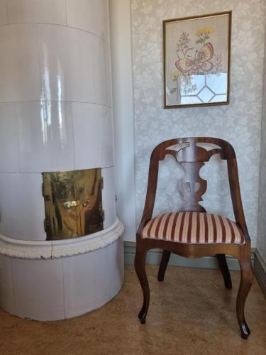 a chair in a room with a fireplace at Villa Eira vandrarhem in Hjo