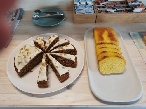 a table with two slices of cake and a plate of bread at Hotel Rural Covarrubias in Covarrubias
