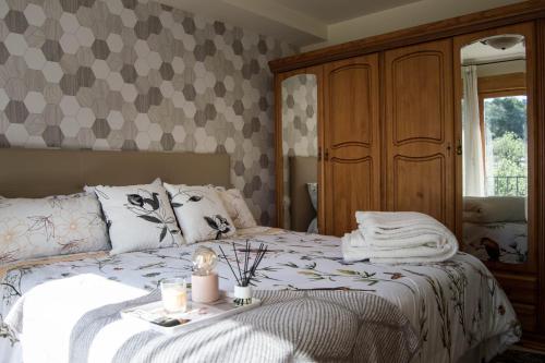 a bedroom with a bed with a night stand and a mirror at El Tossal in El Castell de Guadalest