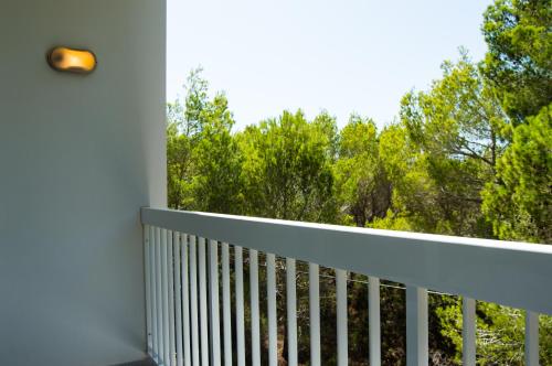 a balcony with a white railing and trees at Es Pi 2 in Playa Migjorn
