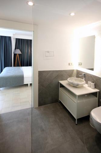 a bathroom with a sink and a bedroom with a bed at Arnna Hotel in Kas