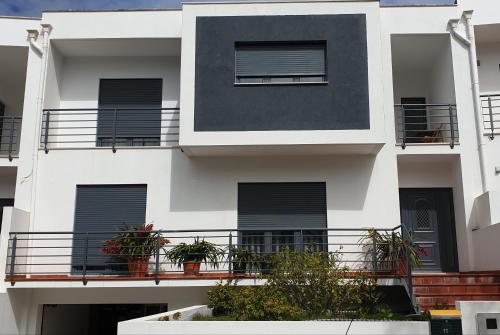 a white building with balconies and plants on it at Vivenda Valverde in Nazaré