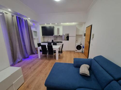 un soggiorno con divano blu e tavolo di Piazza Colombo-Apartments a Sanremo