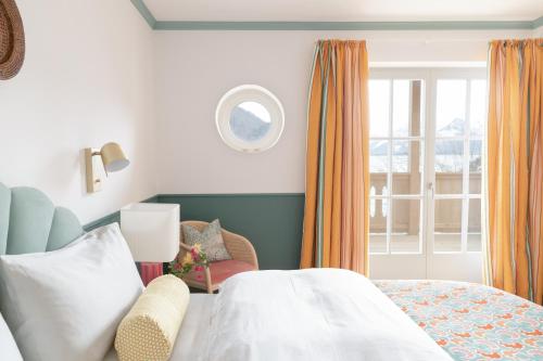 a bedroom with a bed and a window at Villa Alma - a lakeside Boutique Hotel in Sankt Gilgen