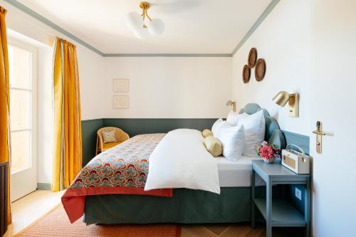 a bedroom with a bed and a table at Villa Alma - a lakeside Boutique Hotel in Sankt Gilgen