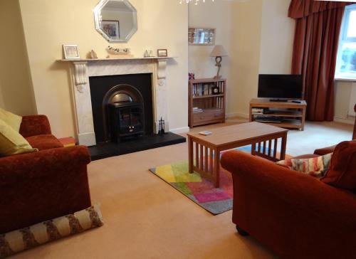 a living room with a fireplace and a tv at The Garden Flat in Hunstanton