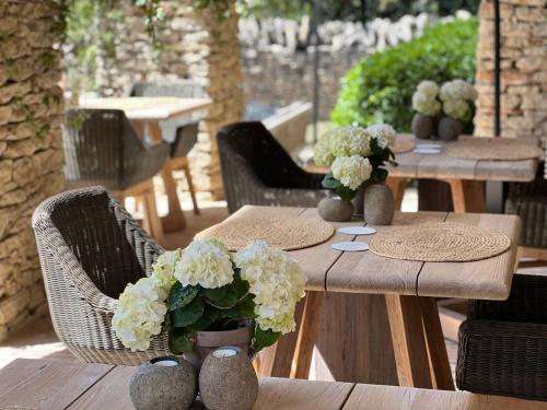 a wooden table with vases with white flowers on it at Le Mas de Béthel in Gordes
