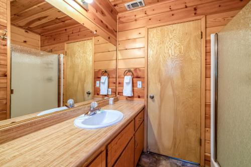 La salle de bains est pourvue d'un lavabo et d'une douche. dans l'établissement Black Bear Cabin, à Bass Lake