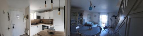 une cuisine avec des armoires blanches et une table à l'intérieur dans l'établissement VILLA AUX CAPELLANS SUR LA MARINA POUR 4 PERSONNES - vue Marina - Parking - plage à 5 min à pied, à Saint-Cyprien