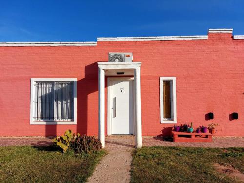 a red building with a white door in front of it at Cabaña Olga in Santa Rosa