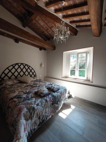 a bedroom with a bed and a window and a chandelier at Casina Laura in Capannori