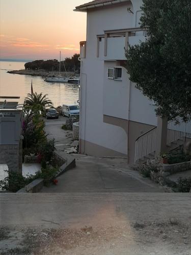 a building next to a body of water at Apartments and rooms LJUBICA in Lun
