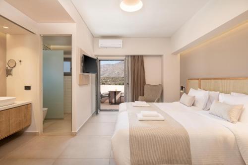 a hotel room with a large bed and a bathroom at Elafonisi Resort by Kalomirakis Family in Elafonisi