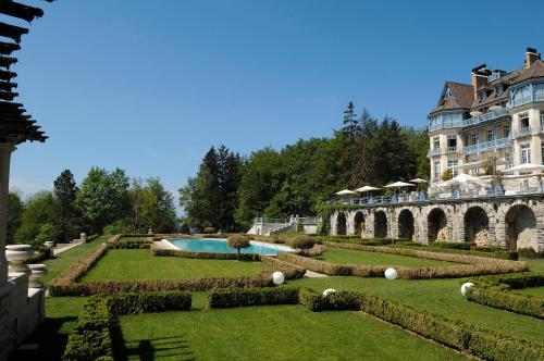duży budynek z ogrodem i basenem w obiekcie Château des Avenieres - Relais & Châteaux w mieście Cruseilles