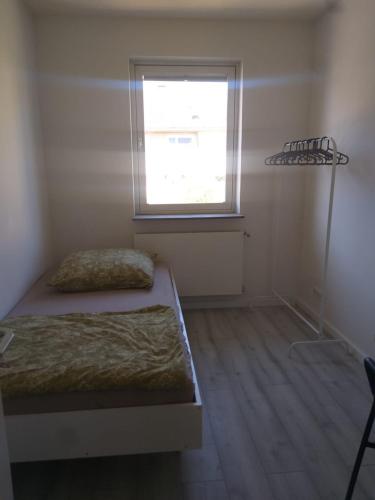 a small bedroom with a bed and a window at Pension Rückert in Kassel