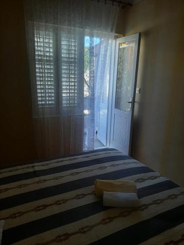 a bedroom with a bed and a door with a window at Apartments and rooms LJUBICA in Lun