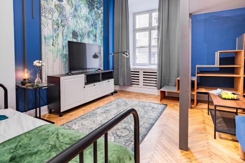 - un salon avec un lit et une télévision dans l'établissement AT Krakow Apartments, à Cracovie