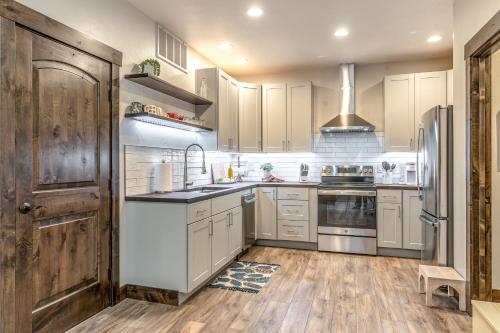 a kitchen with white cabinets and a wooden door at The Electric Bungalow in Bigfork