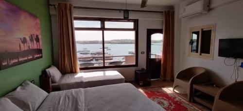 Schlafzimmer mit einem Bett und einem Fenster mit Blick auf ein Boot in der Unterkunft Villa Misk in Assuan