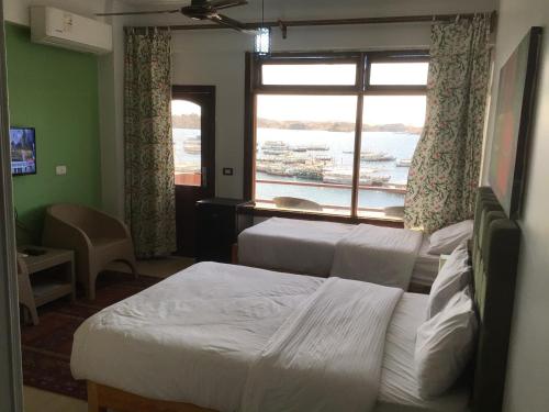 a hotel room with two beds and a window at Villa Misk in Aswan