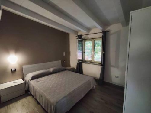- une chambre avec un grand lit et une fenêtre dans l'établissement Aristea Case Vacanza, à Cirella