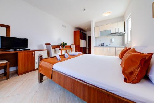 a bedroom with a large bed and a kitchen at Petrovac Holiday Apartments in Petrovac na Moru