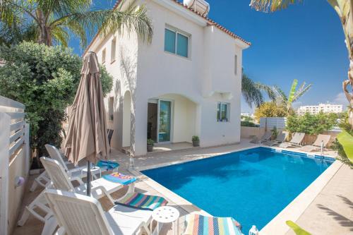 a villa with a swimming pool and a house at George's Lux Villa in Protaras