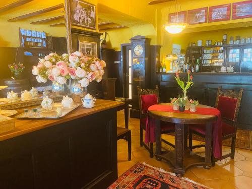un restaurante con mesas, sillas y flores en una habitación en Hotel Anker en Kamp-Bornhofen