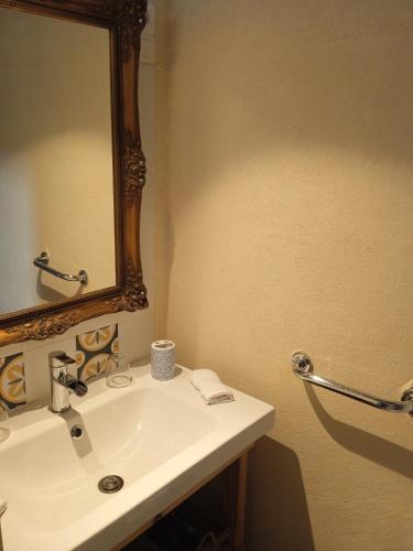une salle de bain avec un lavabo blanc et un miroir dans l'établissement Gite Le pigonnier Ecogite Le Luquet Saint Beauzeil 82150, à Saint-Beauzeil